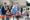 Large group of people cutting ribbon with large scissors
