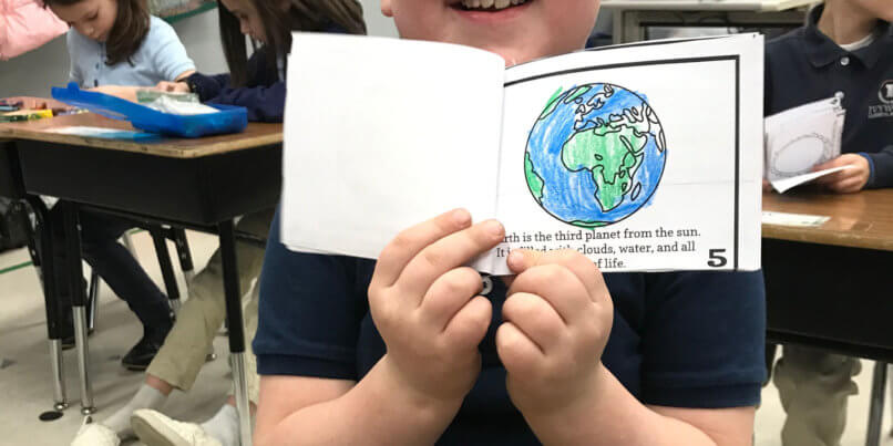 Ivywood student holding up his solar system project