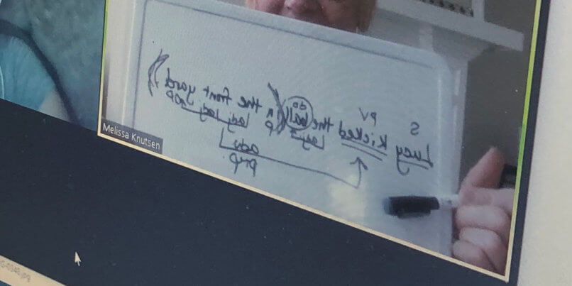 Teacher holding white board of diagramed sentences