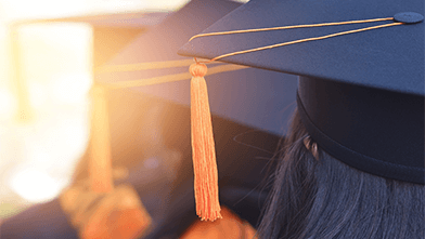 Students with Graduation caps looking into the sun