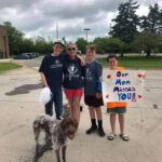 Ivywood teacher with her children and a sign that says "Our mom misses you!"